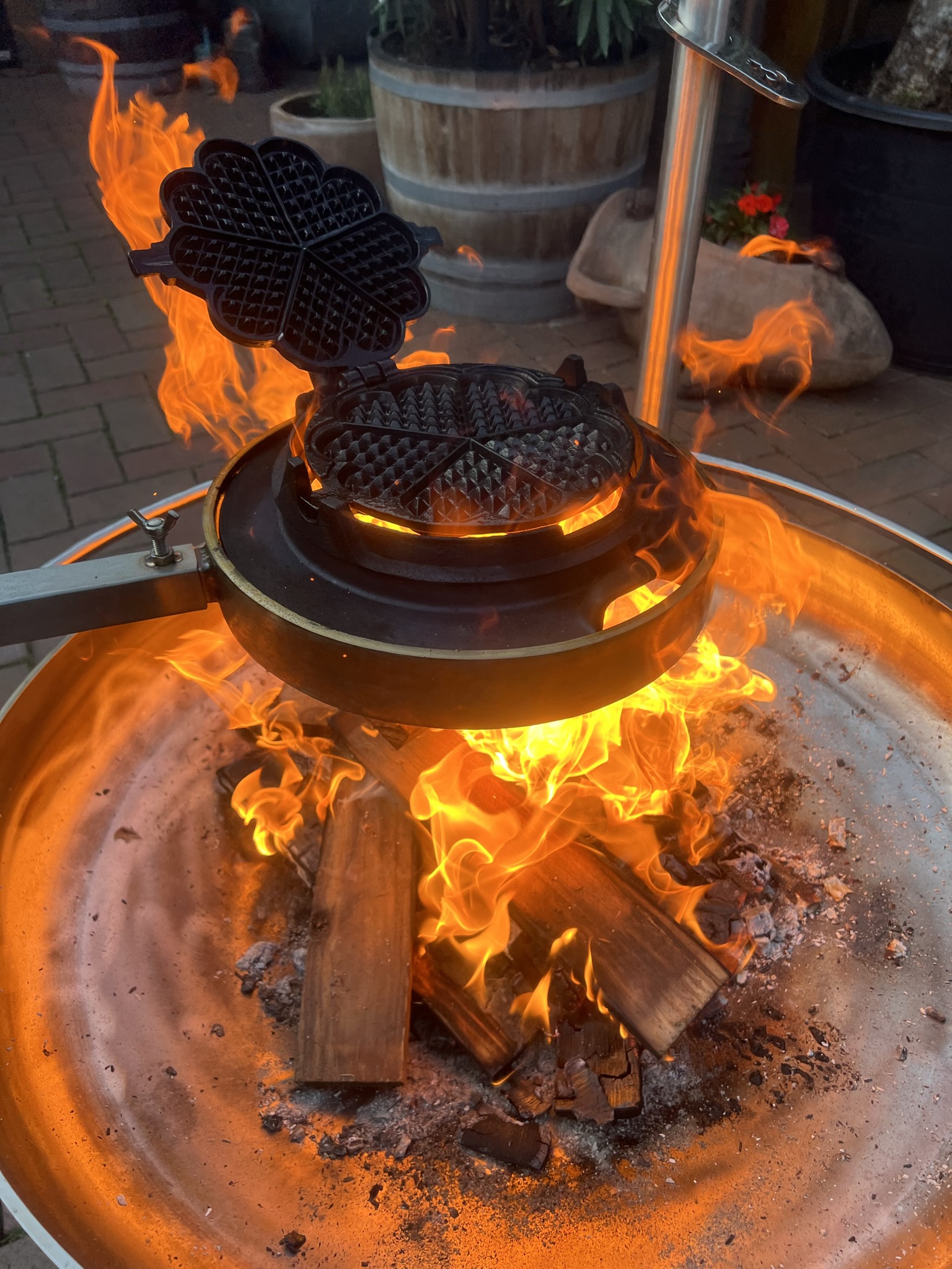 Historisches Waffeleisen über kräftigem Holzfeuer